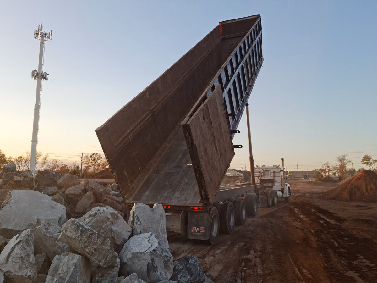 Dump truck unloading construction material; illustrative truck photo for the dump trailer rentals and truck rentals page
