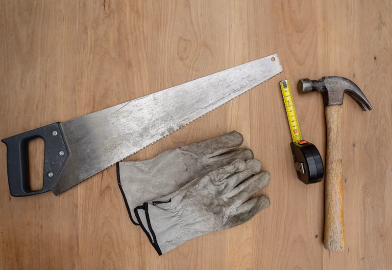 Carpentry tools on a wooden surface illustrating handyman services (stock photo)